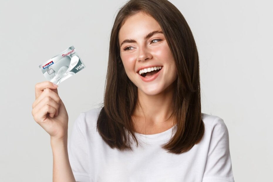 Mulher sorridente segurando o cartão de crédito Casas Bahia.